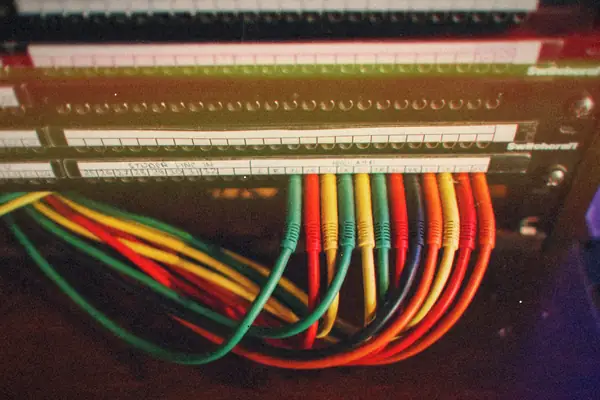 Colorful patch cables running into a labeled network patch panel.