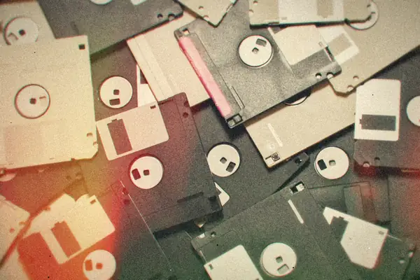 A pile of old 3.5-inch floppy disks in assorted colors.