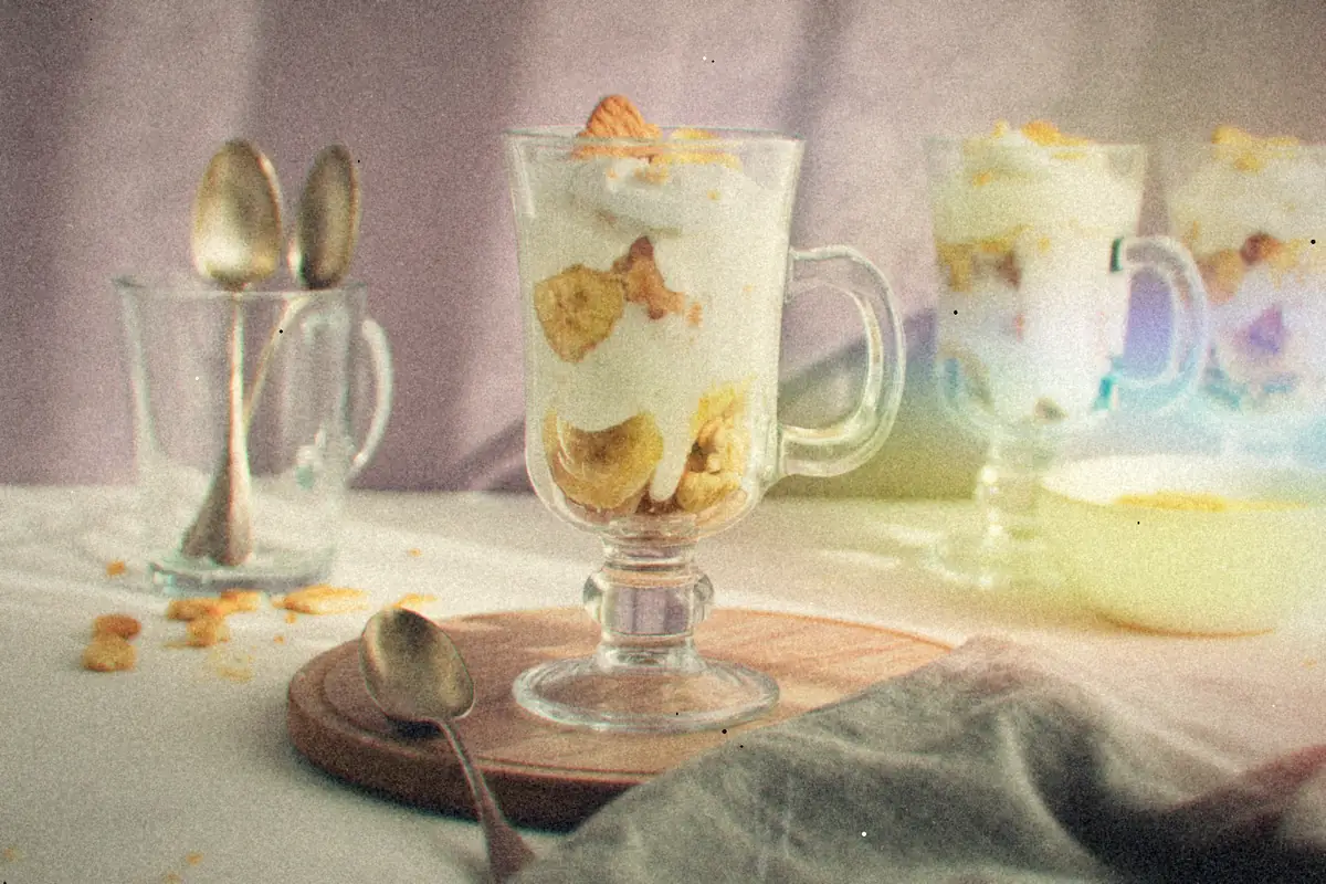 Glass cups layered with cream, banana slices and vanilla wafers.