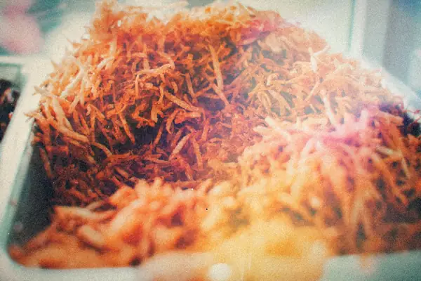 A heap of golden shredded potatoes piled in a pan.