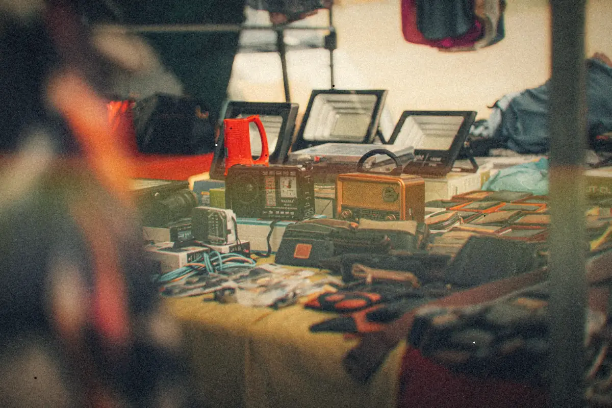 A flea market table covered with vintage radios, gadgets and odds and ends.