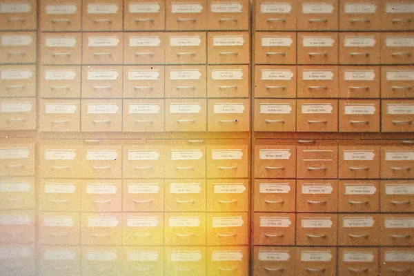 A wall of small labeled wooden index drawers.