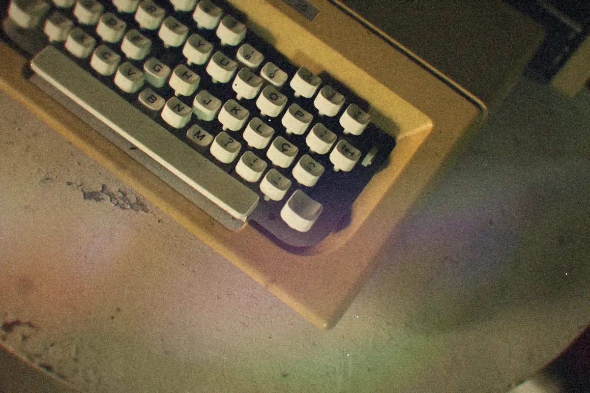 The keys of a cream-colored vintage typewriter on a rustic table.