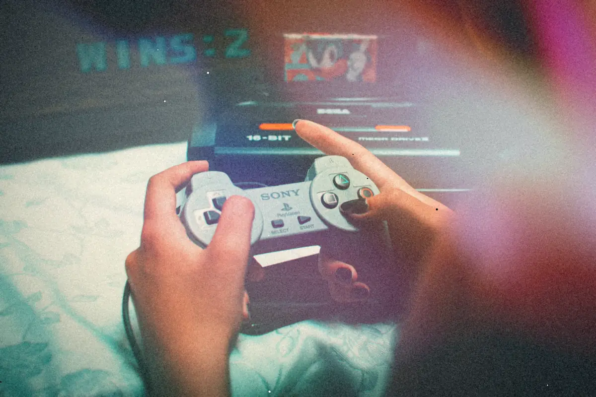 Hands holding a game controller in front of a Sega Mega Drive with a Sonic cartridge plugged in.