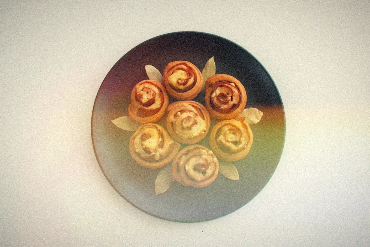 Baked ham and cheese pinwheel rolls arranged on a black plate.