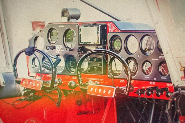 The dual control yokes and round gauges of an old small-plane cockpit.