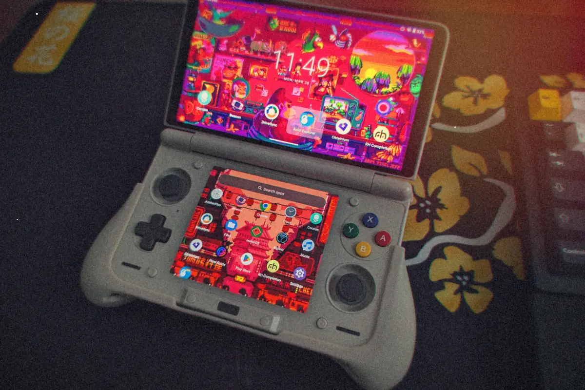 An AYN Thor dual-screen handheld opened on a desk, both screens lit up with Android home screens.
