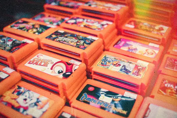 Rows of stacked orange retro game cartridges with colorful label art.