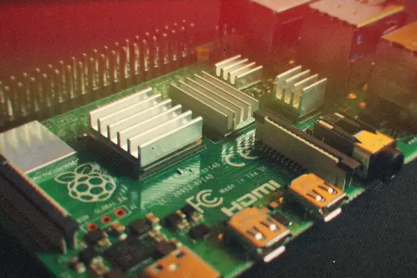 A close-up of a Raspberry Pi board with heatsinks on its chips and its USB and Ethernet ports.