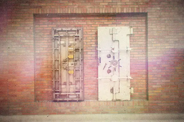 Two heavy steel vault doors set into an old brick wall.